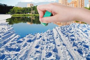 hand deletes winter snow field by rubber eraser photo