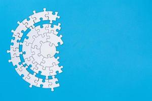 White jigsaw pieces on a blue background, Copy space, Concept image of unfinished task.  missing jigsaw puzzle pieces and business concept with a puzzle piece missing. photo