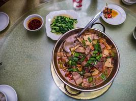 Top view of Larouguo or Spicy Smoked pork hotpot in chinese restaurant.Smoked pork famouse food in fenghuang old town hunan china photo