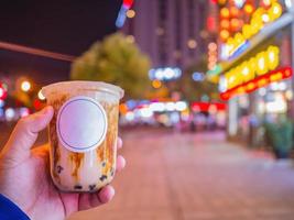 té de leche de burbujas con mezcla de azúcar oscura en el té de leche en la mano turística en la ciudad china de zhangjiajie foto