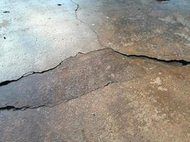 Cracked concrete ground broken at floor home or street road subside from earthquake photo