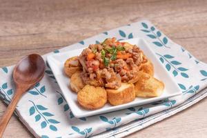 Fried tofu stir fried with ground pork and vegetables in white plate photo