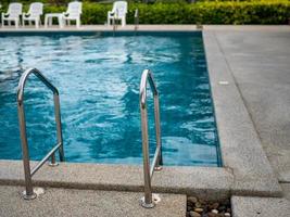 Escaleras de acero inoxidable a la piscina. Pasamanos arriba y abajo de la piscina. foto