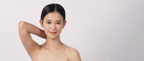 hermosa mujer asiática joven con piel limpia y fresca sobre fondo blanco. foto