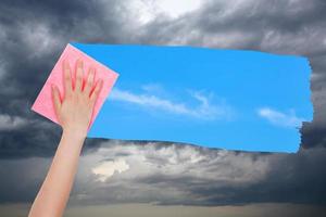 la mano elimina las nubes de tormenta con tela rosa foto