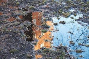 House reflection in the spring puddle photo