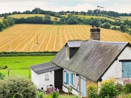 peasant farm and harvested field in Normandy photo