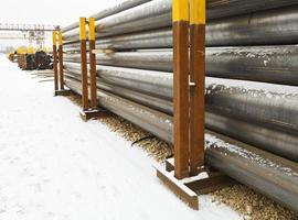 stacks of construction pipes on outdoor warehouse photo