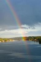 rainbow in rain during sunshine in Baltic sea photo