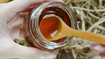 Honig mit einem Holzlöffel ausschöpfen. Nahaufnahme Makroaufnahme, Draufsicht flach liegend. video