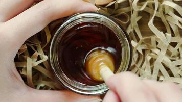 Mixing honey with a honey dipper. Close up top view shot. video