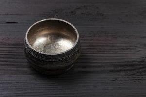 empty vintage silver salt cellar on wooden board photo