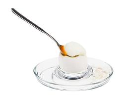 huevo blanco pasado por agua con una cuchara en una huevera de vidrio foto