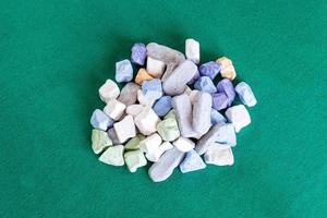 pile of various multicolored stones on green table photo