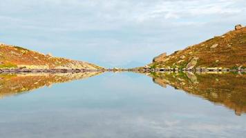 4k uhd berg sjö Timelapse höst tid. vild natur och lantlig montera dal. falla grå väder regnig moln på himmel. kall sjö, vinter- kommande landskap video