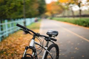 White bicycle standing in park. Morning fitness, loneliness. photo