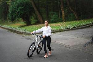 hermosa chica posando en bicicleta blanca. caminar en la naturaleza. foto