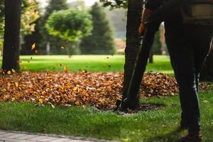 A woman operating a heavy duty leaf blower. photo