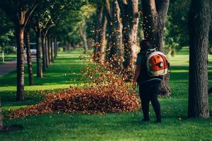 A woman operating a heavy duty leaf blower. photo