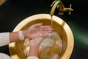 foto de cerca de una mujer que se lava las manos con agua y jabón.