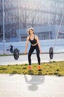 mujer fuerte haciendo ejercicio con barra. deportes, concepto de fitness. foto