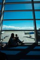 Little boy and his mother sitting in an airport photo