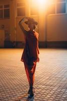 The young, attractive girl in a hat poses to the camera at night photo