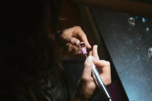 girl master processes the metal plate in the home workshop photo