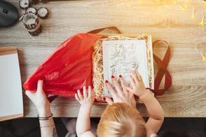 Woman wrapping present in paper with red ribbon. photo