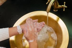 foto de cerca de una mujer que se lava las manos con agua y jabón.