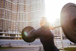 Strong woman exercising with barbell. Sports, fitness concept. photo