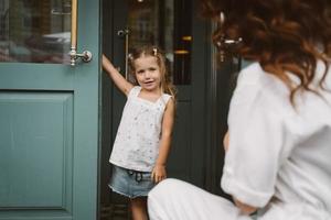 Young mother and cute little daughter walking down the street photo