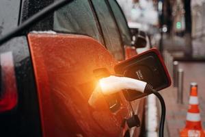 Electric car with power cable supply plugged in photo