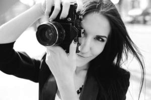 Beautiful female photographer posing with camera photo