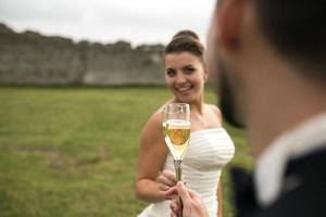 bridal couple clink glasses of champagne photo