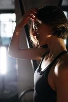 Portrait of Confident Brunette Woman Wearing Performance Wear in Gym photo