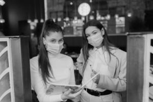 dos chicas en la entrada del edificio están revisando a la gente foto