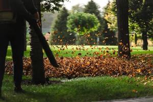 A woman operating a heavy duty leaf blower. photo