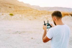 Guy controls drone with remote control photo