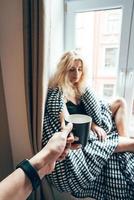 girl sitting on a window in a blanket photo