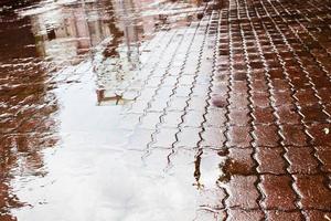 charco de lluvia en la plaza urbana foto