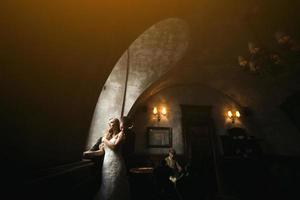 The bride and groom in a cozy house, photo taken with natural light from the window.