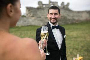 bridal couple clink glasses of champagne photo