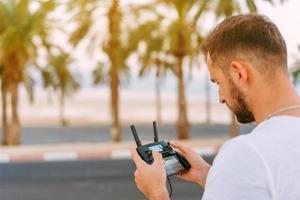 Guy controls drone with remote control photo