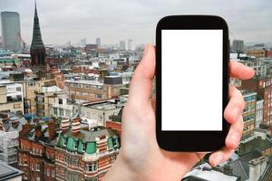 teléfono inteligente con pantalla recortada y horizonte londinense foto