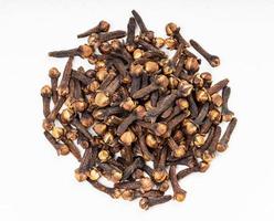 pile of whole dried cloves close up on gray photo