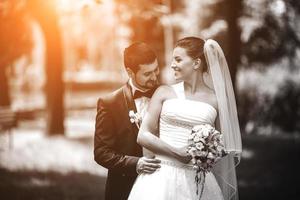 groom embracing bride from back photo