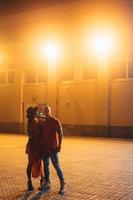 A young sexy couple lovers pose on the night street of the city. photo