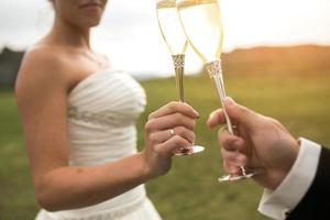 bridal couple clink glasses of champagne photo