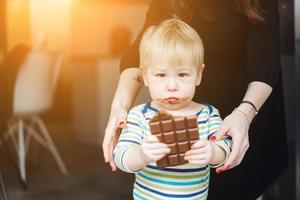 Portrait of an littel boy eating chocolate photo